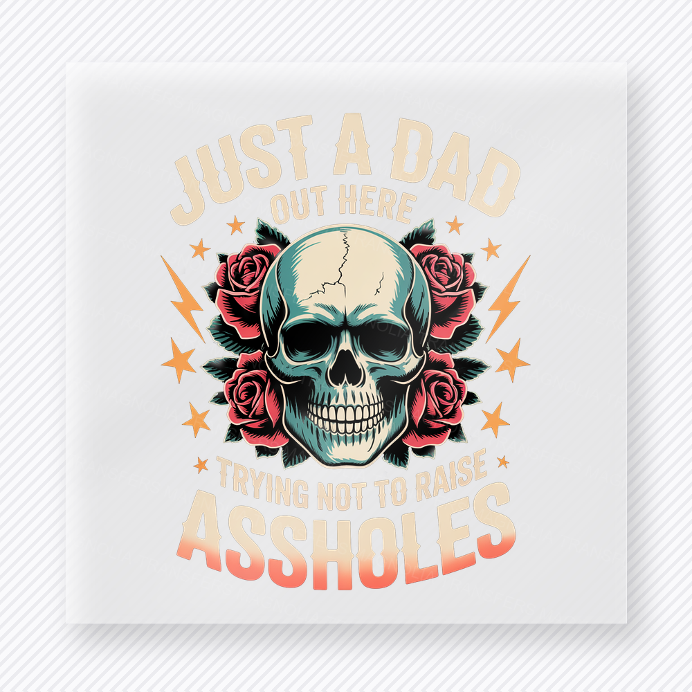 Just A Dad Trying Not To Raise Assholes Peach DTF transfer mockup with just A Dad Out Here Trying Not To Raise Assholes wording surrounds a skull, roses, lightning, and peach accents.